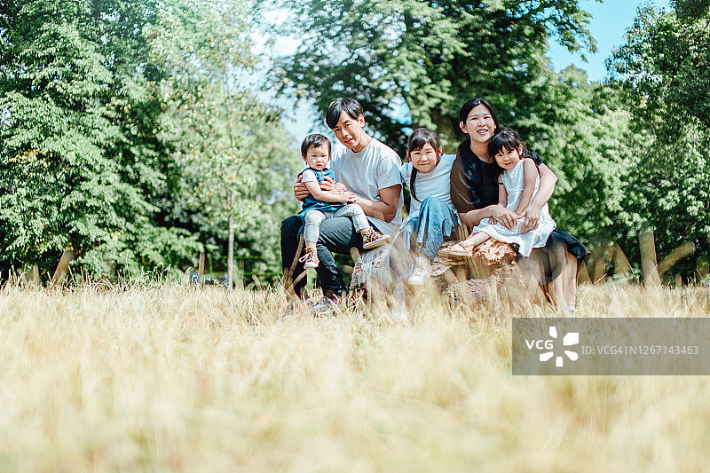 在阳光明媚的日子里，快乐的小家庭在大自然中放松图片素材