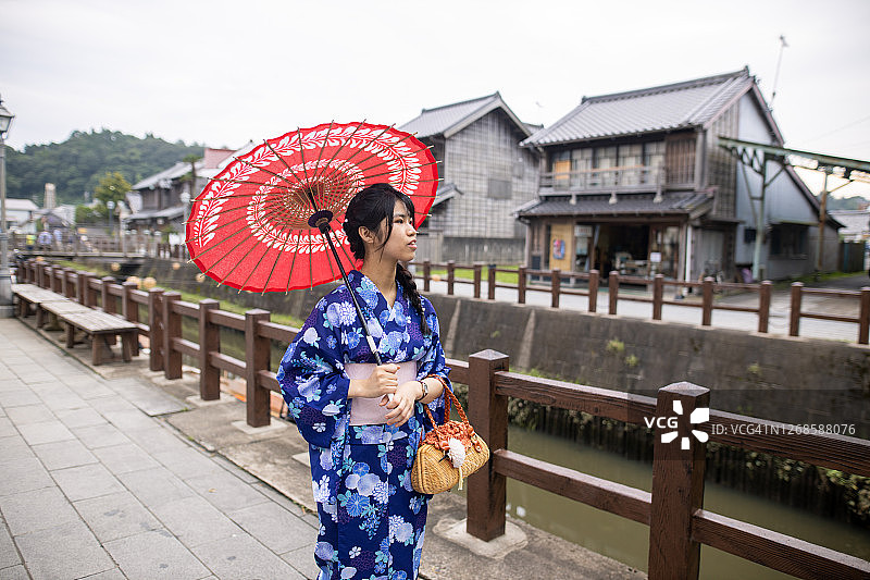 十几岁的女孩在浴田参观一个古老的日本村庄图片素材
