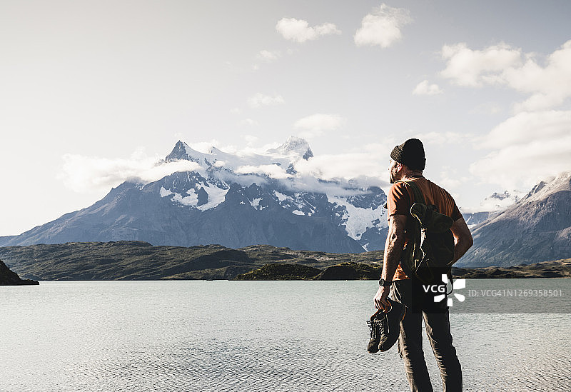 南美，智利，巴塔哥尼亚，托雷斯。德尔。潘恩国家公园，一名穿着鞋子的男子正在欣赏佩霍湖图片素材