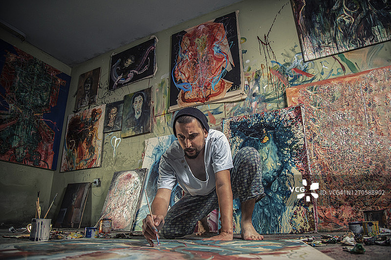 艺术家-画家在他的艺术工作室的一个新的画布上工作图片素材