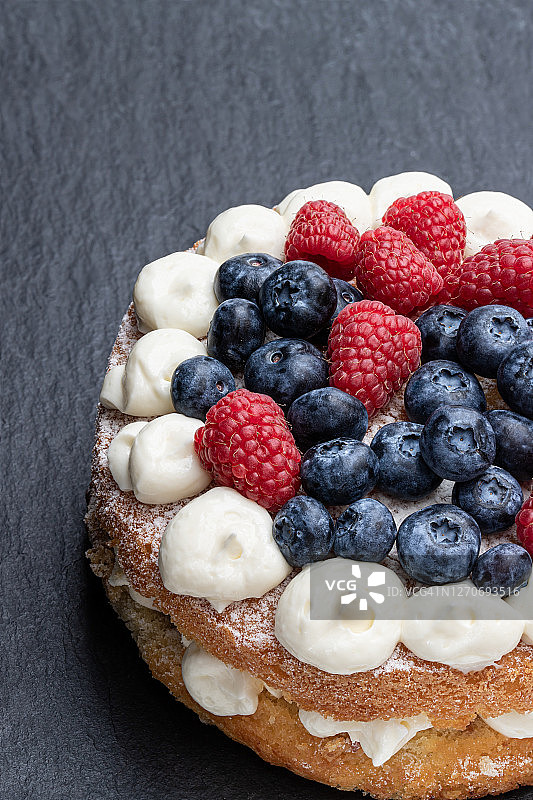 维多利亚海绵蛋糕，奶油和浆果顶部的石头背景图片素材