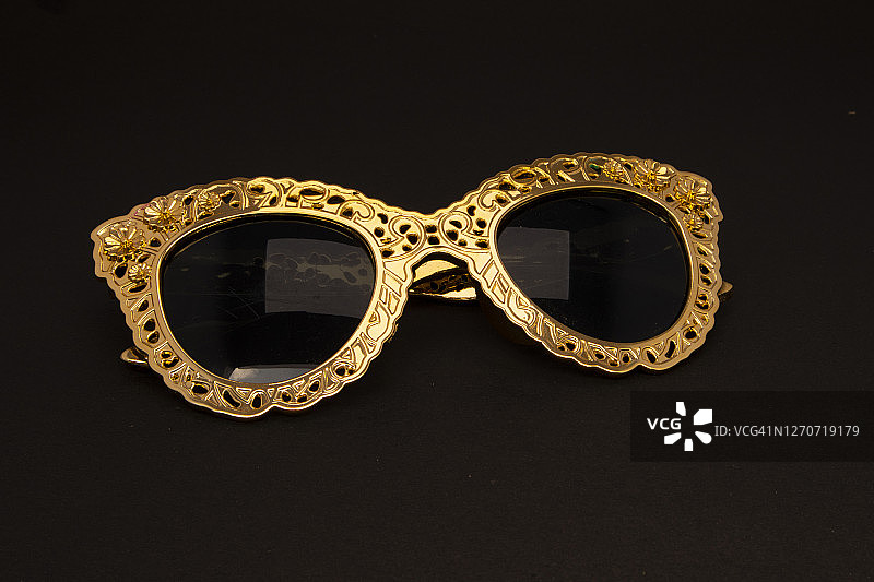 时尚眼镜配件，金色镜框太阳镜。主题派对的道具。图片素材