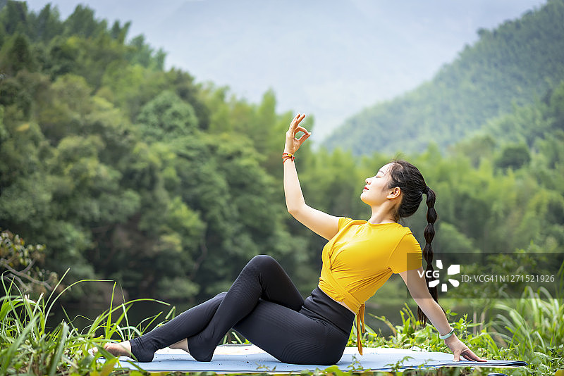 一个女人在湖边做瑜伽图片素材