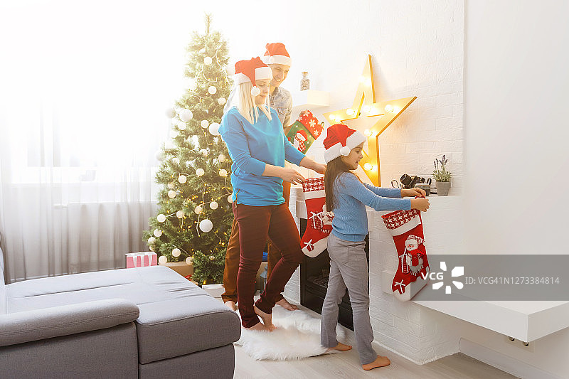 快乐的年轻家庭在家里庆祝圣诞节图片素材