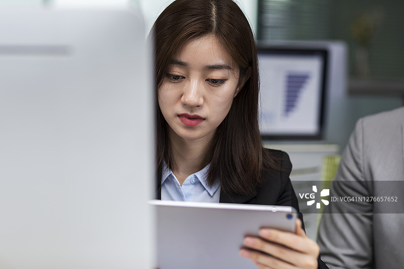 描绘年轻的亚洲女商人拿着平板电脑图片素材