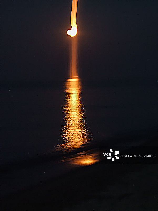 黄昏时海面上的月亮倒影。图片素材