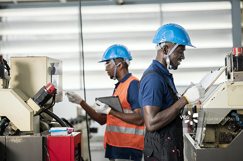 非洲工业工人在自动化生产线上工作。图片素材