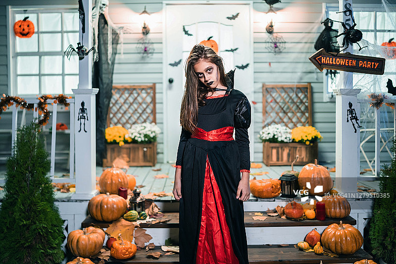 女孩在吸血鬼服装有乐趣的万圣节trick or treat图片素材