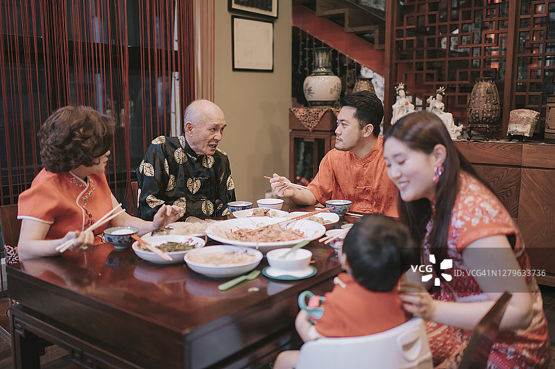 亚洲华人家庭春节团圆饭吃传统菜肴生鱼刘生图片素材
