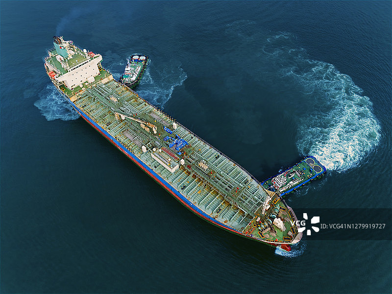 航拍俯视图油船推油船到装载码头，用于海上运输炼油厂的石油，商业物流，进出口运输或货运。图片素材