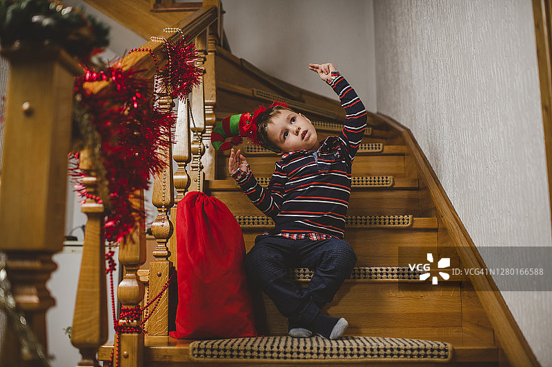 可爱的小男孩打开圣诞礼物，表达兴奋和快乐图片素材
