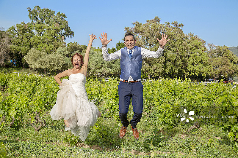 看到一对年轻的夫妇，他们在葡萄园里快乐地拥抱着空气。图片素材