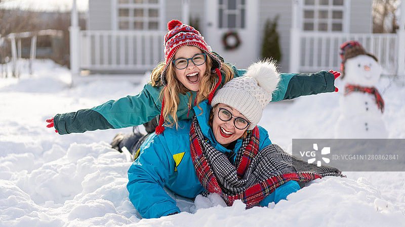 幸福的家庭母亲和女儿在冬天的背景美国房子图片素材
