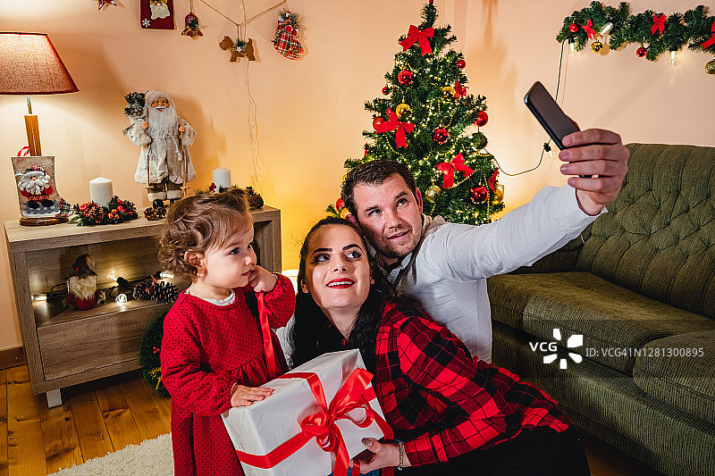 父母和女孩在拍圣诞自拍图片素材