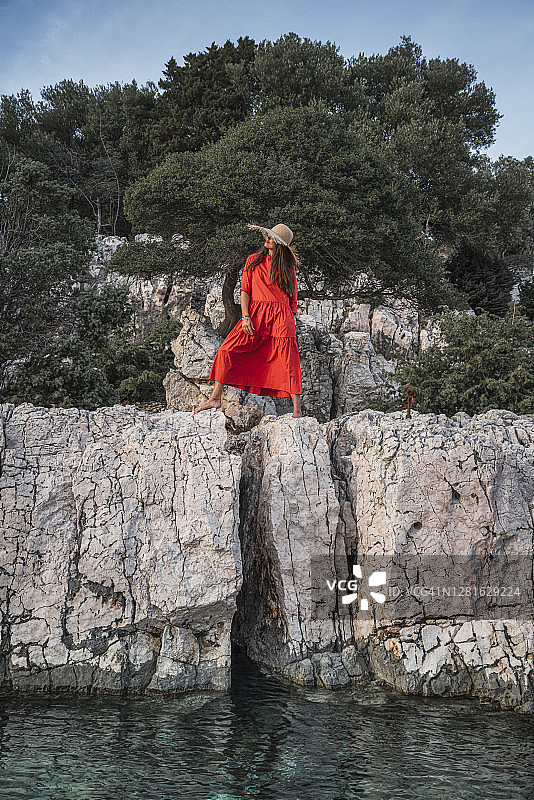 穿红夏装的女人，站在石头上图片素材