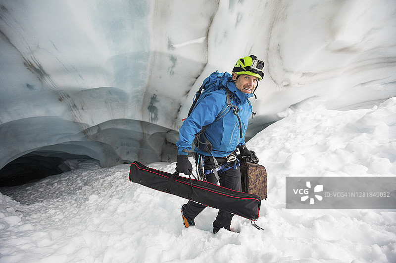 加拿大不列颠哥伦比亚省，一名科学家带着设备走出一个冰洞图片素材
