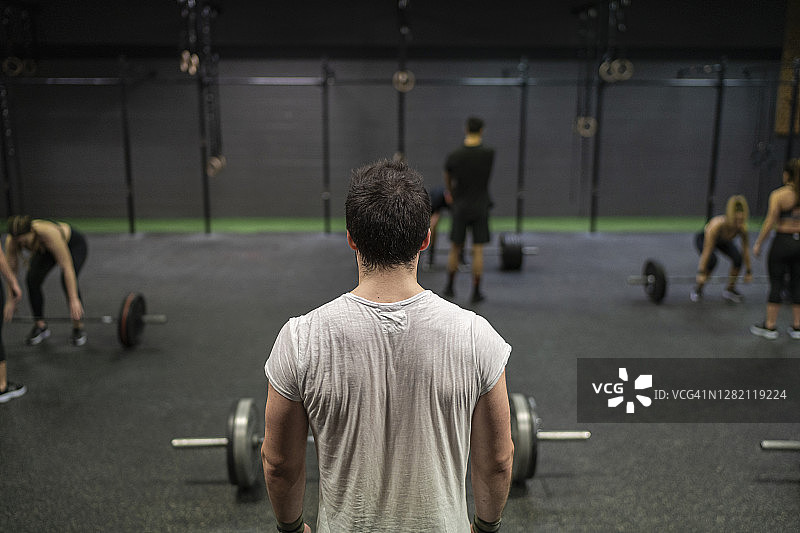 一个男人站在体育馆里和运动员一起锻炼图片素材