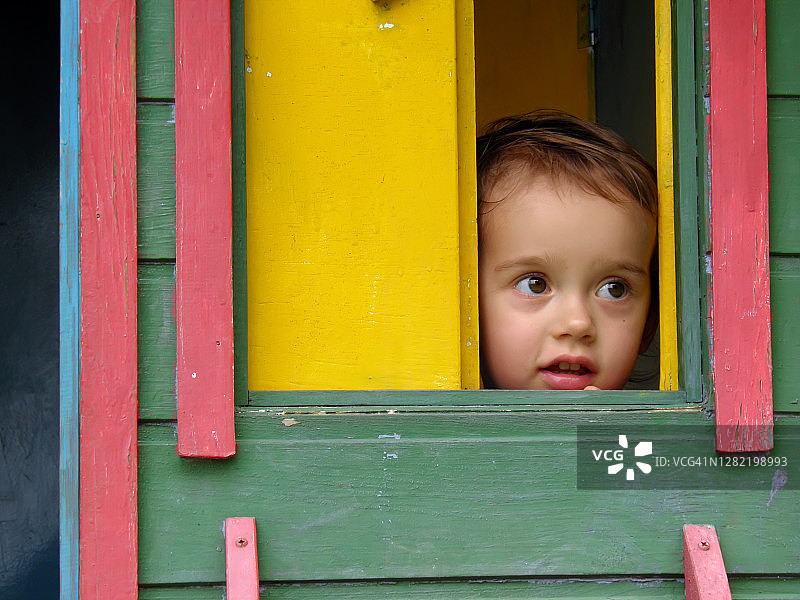 快乐的小女孩，在五颜六色的木屋里。图片素材