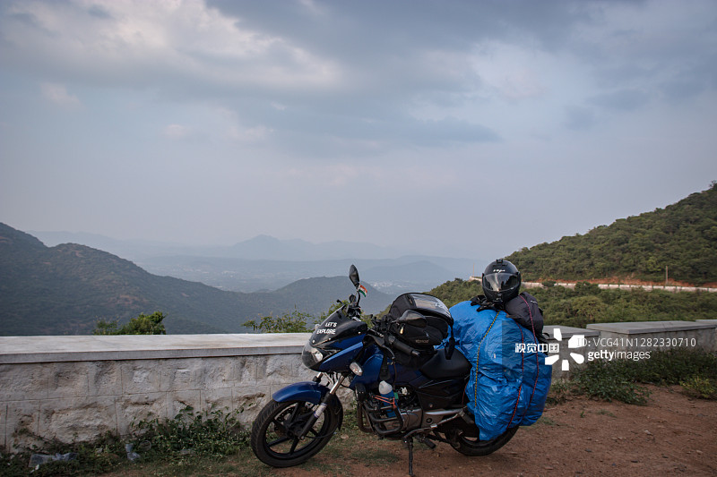 独自旅行者装载自行车与惊人的背景在山顶图片素材