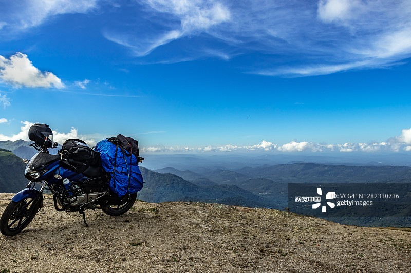 独自骑着自行车，从山顶俯瞰蓝天，感受大自然图片素材
