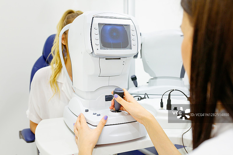女眼科医生使用电子设备进行眼部检查图片素材