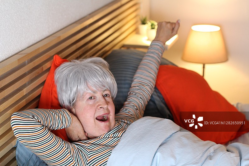 放松的老女人在床上打哈欠图片素材