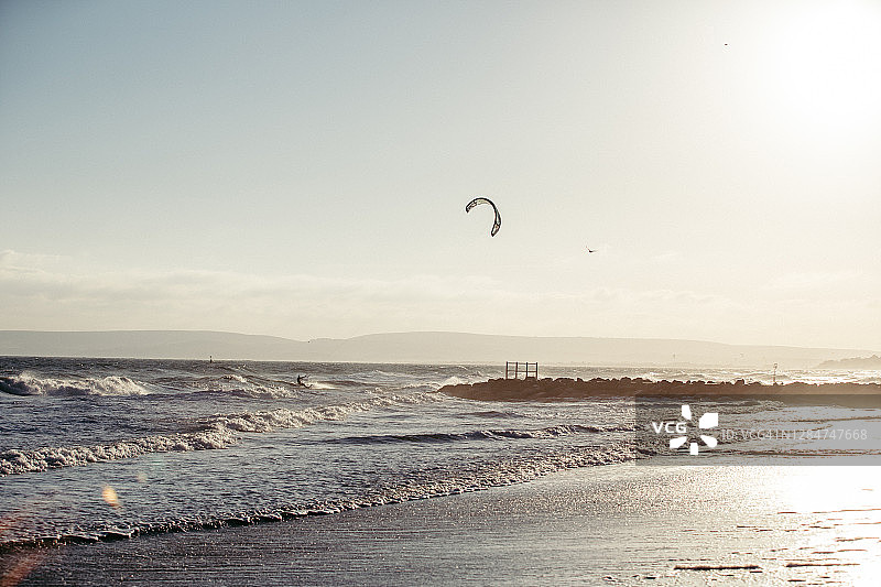 在日落的波浪中风筝冲浪者图片素材