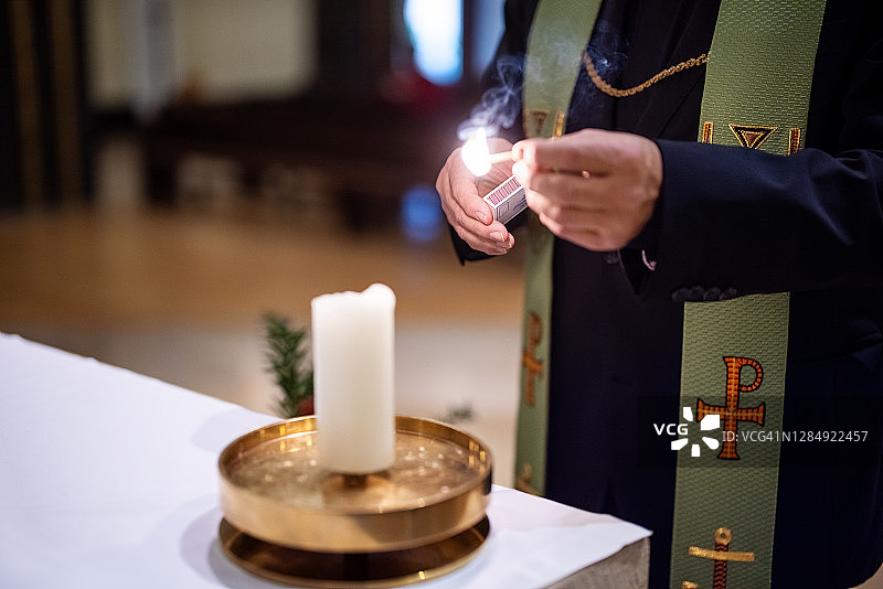 牧师在教堂里点燃蜡烛图片素材