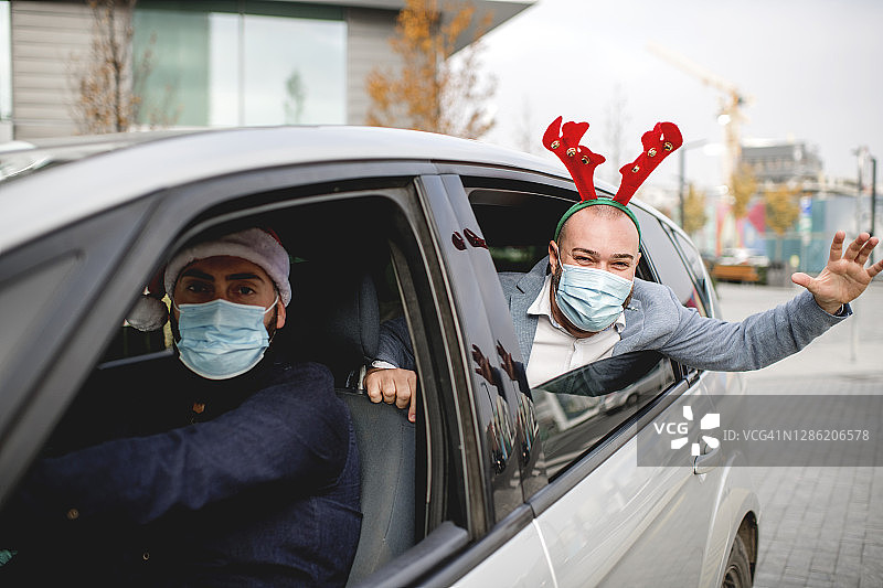 朋友们在车上戴着防护面罩。假期期间流行。图片素材