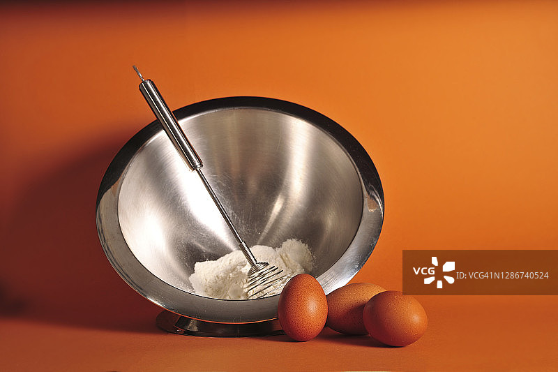 面粉和鸡蛋放在一个银碗里图片素材