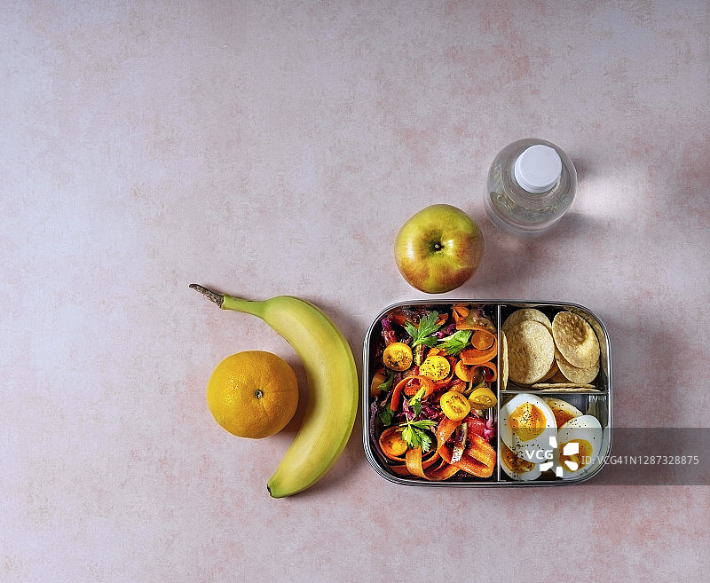 午餐盒水果，和一瓶水在桃子的背景图片素材