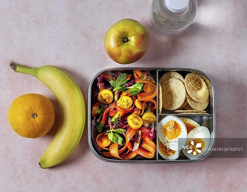 带水果的午餐盒，粉色背景的一瓶水图片素材