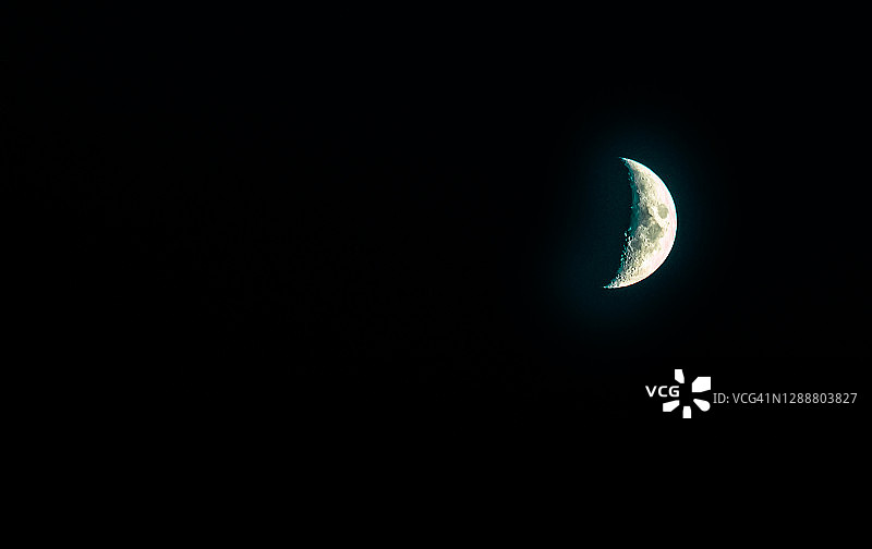 黑暗夜空中的新月。图片素材