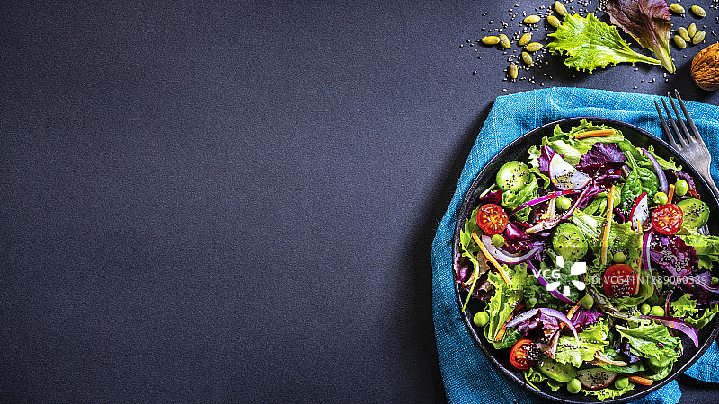 深色背景上的新鲜蔬菜沙拉盘。本空间图片素材