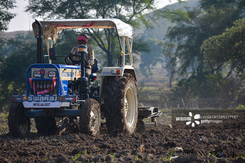 印度农民用拖拉机准备用耙播种。图片素材