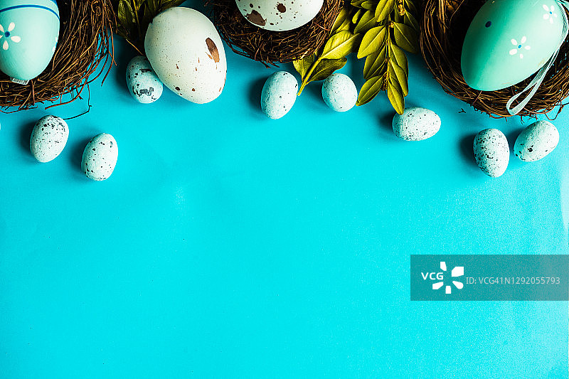 在蓝色背景上绘制复活节彩蛋和燕窝装饰图片素材