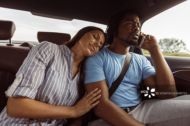 一名年轻女子在开车时睡在男友的肩膀上图片素材