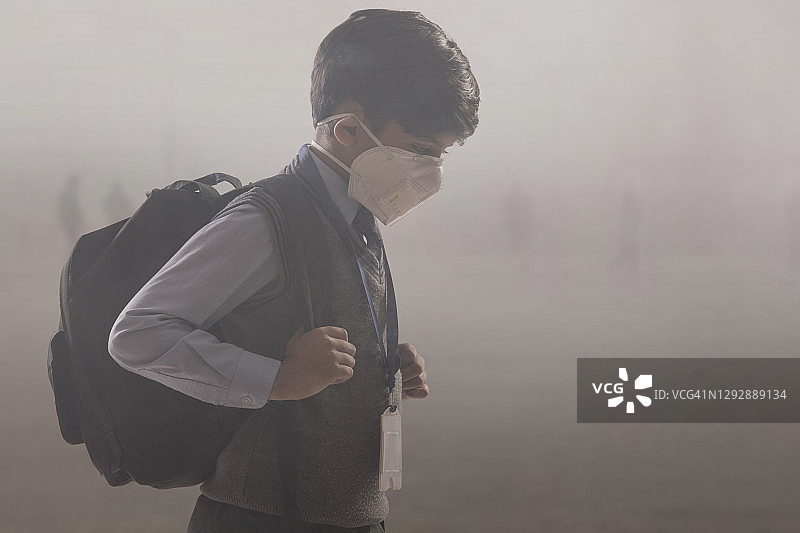 小男孩戴着防毒面具上学。图片素材