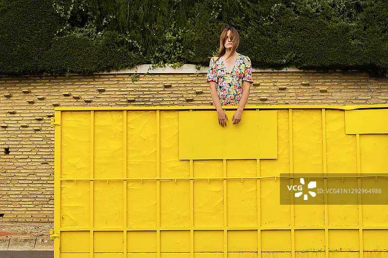 一个女人站在黄色的容器里，环顾四周图片素材