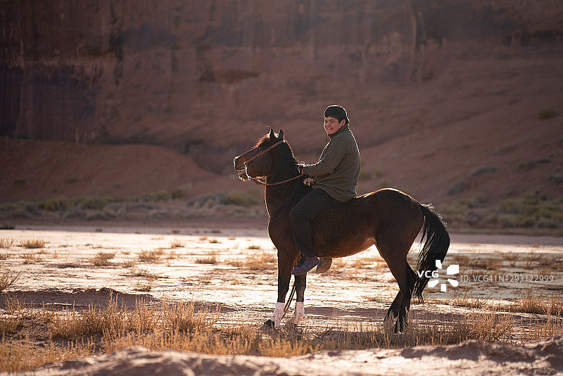纳瓦霍少年骑马疾驰在美国亚利桑那州的沙漠中图片素材