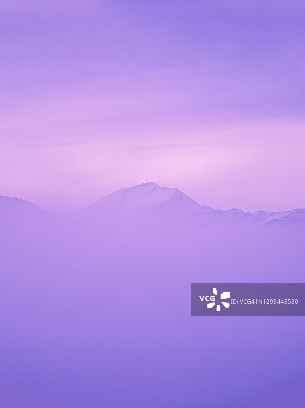 奇异的山覆盖着紫色的雾，超现实的灵感景观图片素材