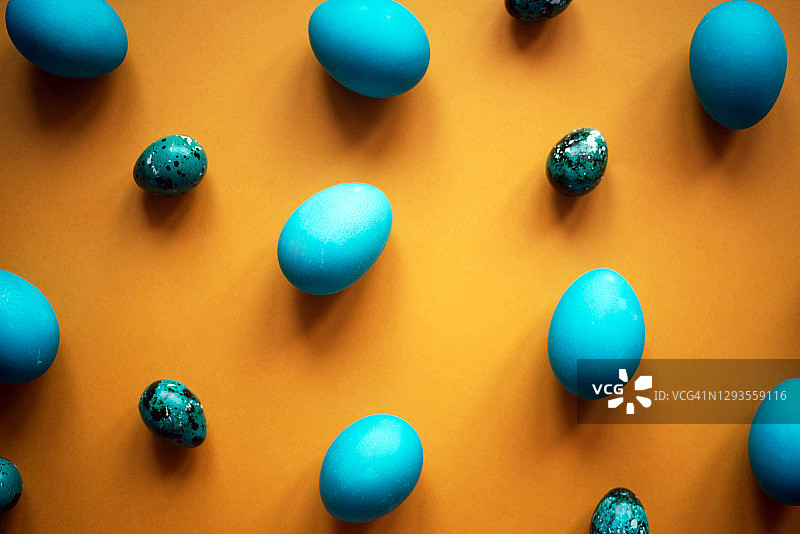 一种以橙色为背景的蓝色鸡蛋图案。图片素材