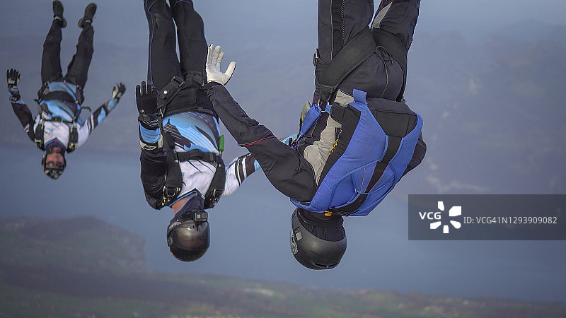 自由落体跳伞者在半空中飞过山脉和山谷图片素材