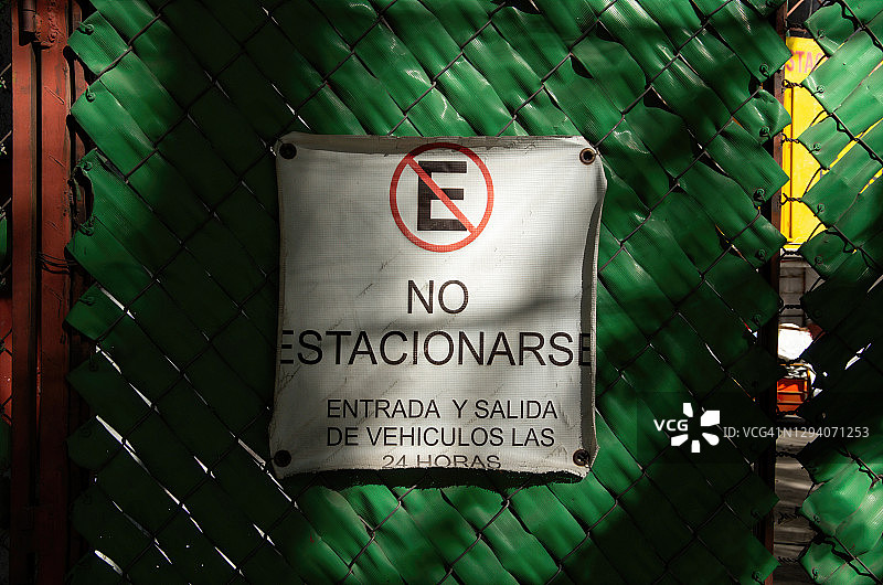 铁链门上有个西班牙语的牌子，上面写着“没有权利”。Entrada y salida de vehículos las 24 horas'禁止停车。车辆24小时进出]图片素材