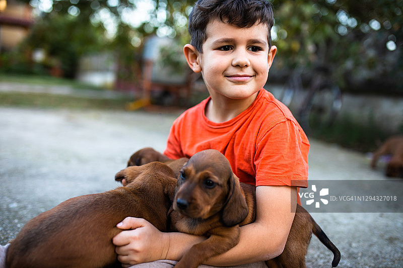 一个男孩和小狗在一起很开心图片素材