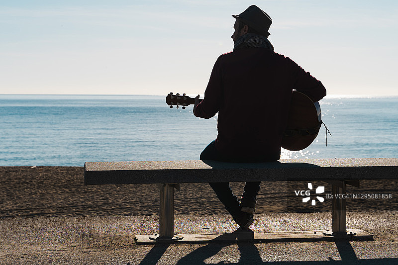 一个人在大海前弹吉他的剪影图片素材