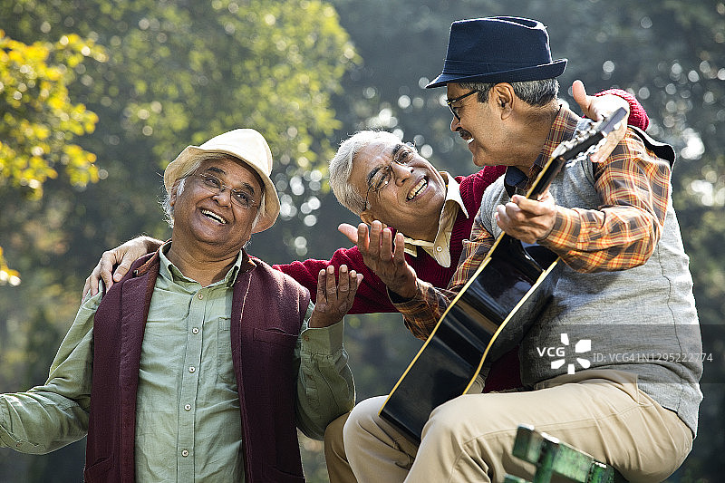 三个老人在公园玩吉他，玩得很开心图片素材