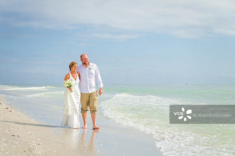 新娘和新郎沿着海边散步图片素材