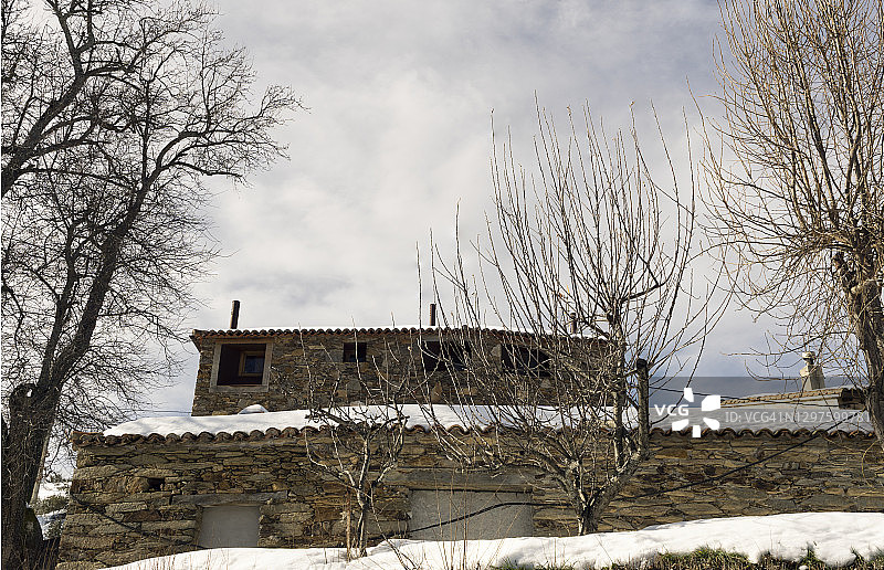 雪废弃的乡村石屋。图片素材