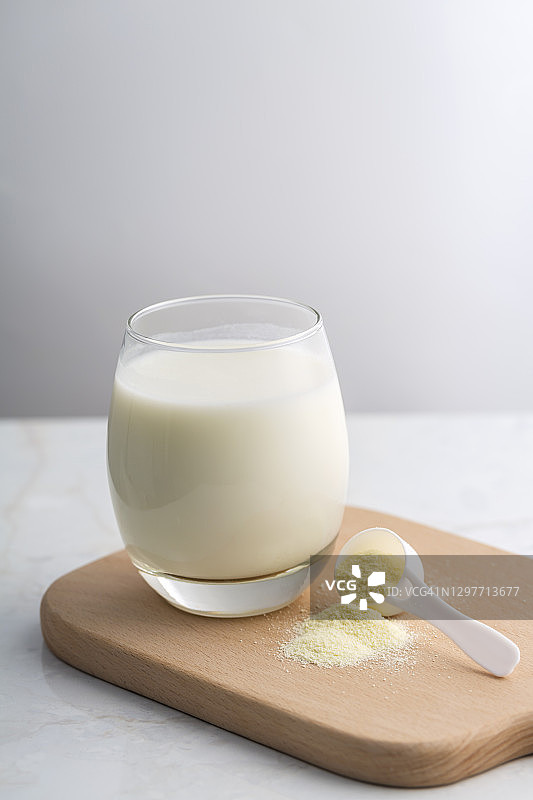 一杯牛奶加奶粉和一个勺子图片素材